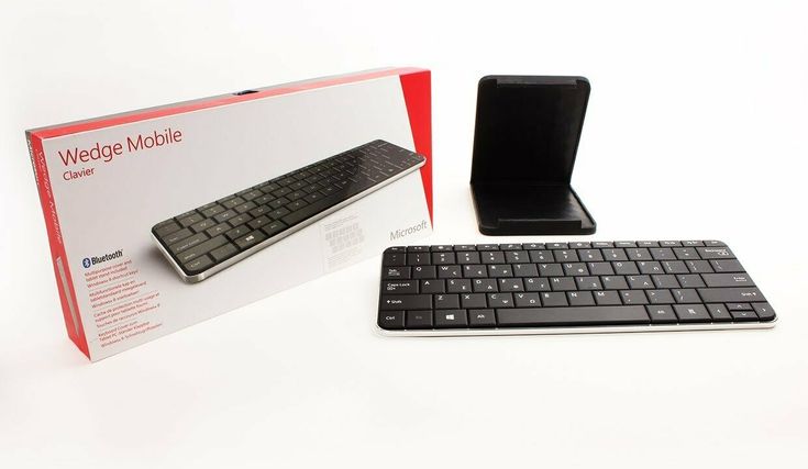 a wireless keyboard and mouse sitting next to each other on a table with a box