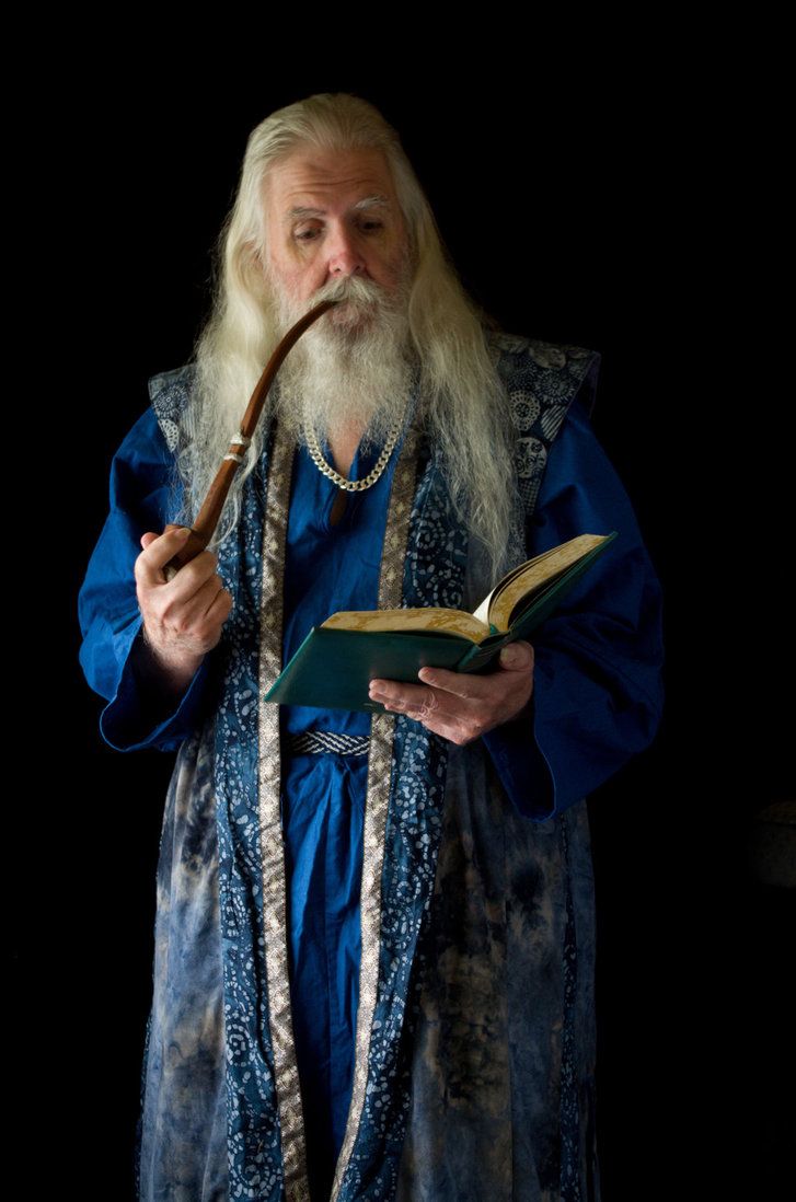 an old man with long white hair is holding a pipe in his hand and reading a book