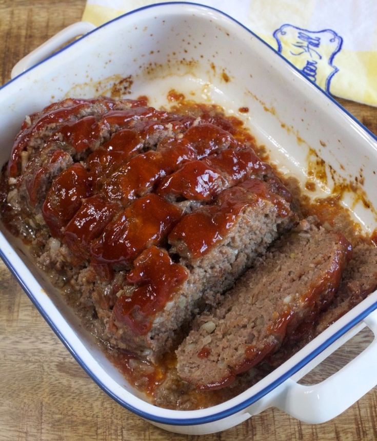 meatloaf in a blue and white casserole dish on a wooden table