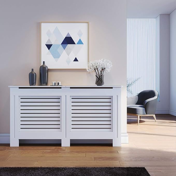 a white sideboard with two drawers and vases on top in a living room