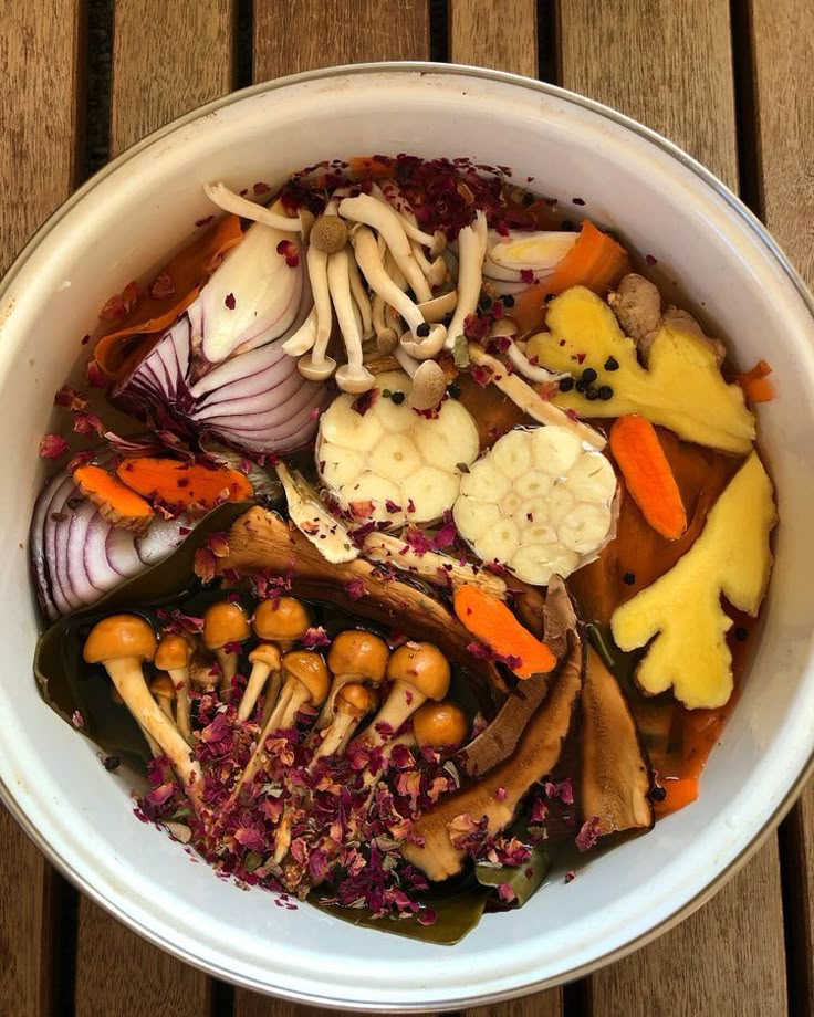 a bowl filled with lots of different types of food on top of a wooden table