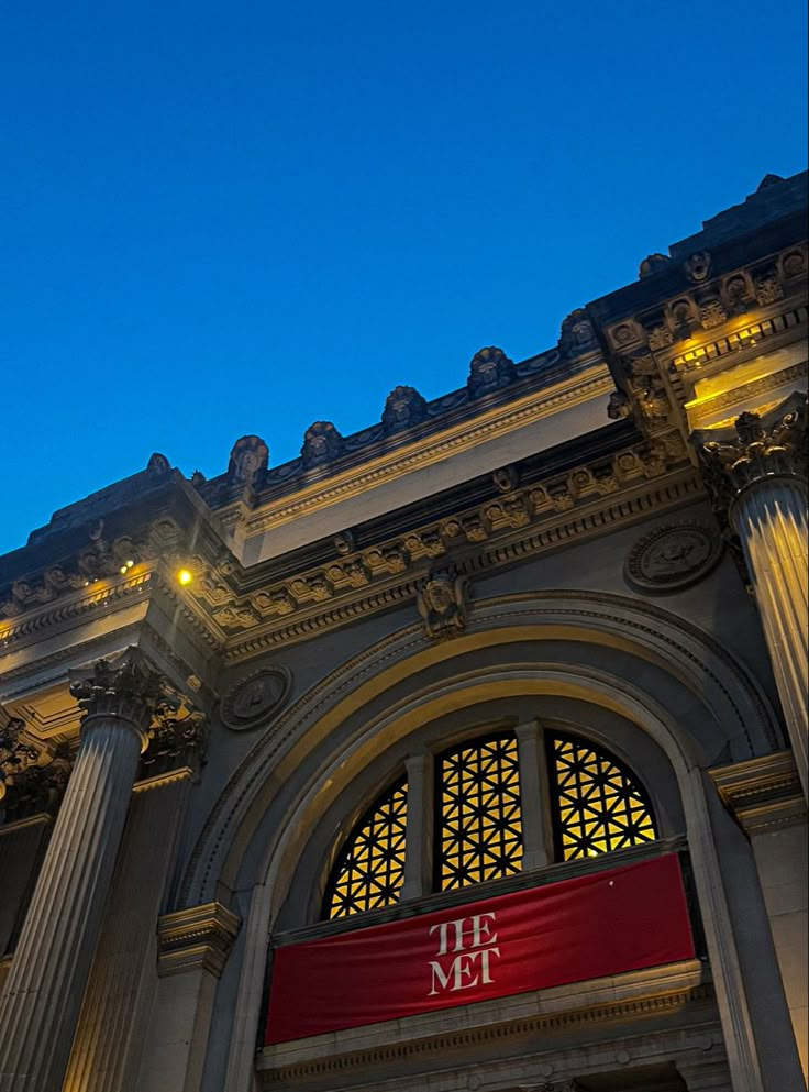 an ornate building with columns and lights at night