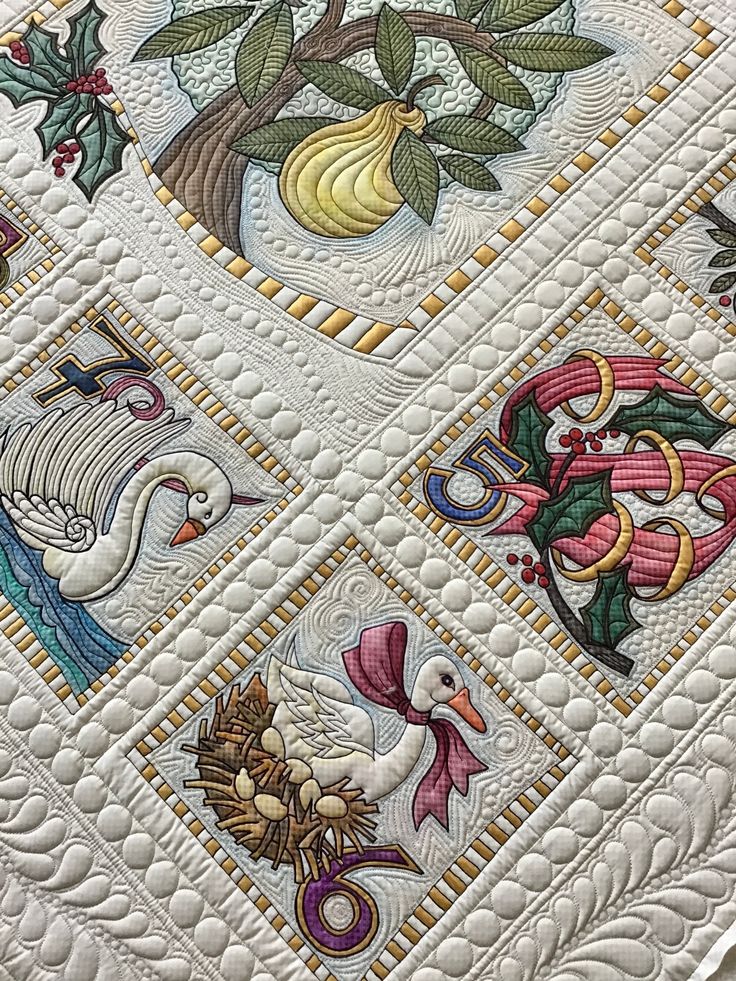 a quilted wall hanging with birds, flowers and leaves on it's sides