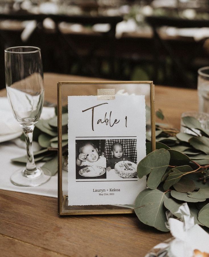 a table is set with place cards and greenery