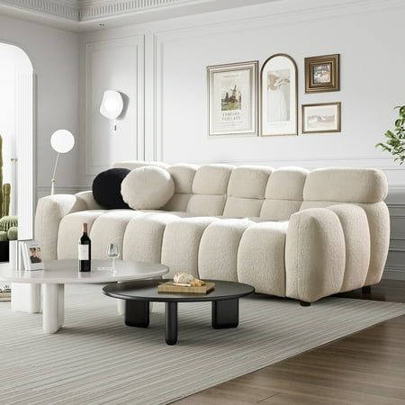 a living room filled with furniture and a coffee table on top of a white rug