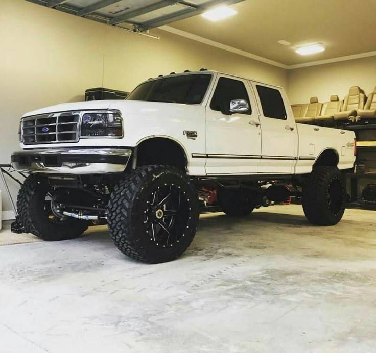 a white truck parked inside of a garage