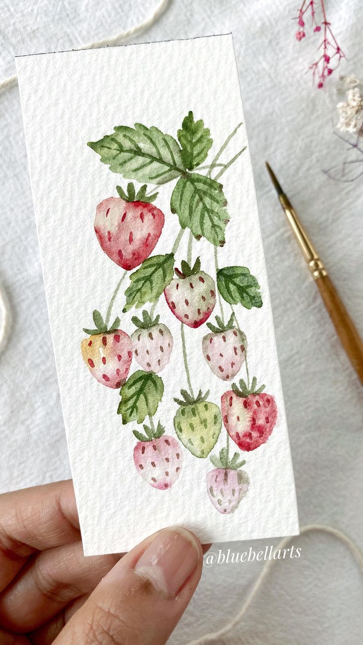 a person holding up a card with strawberries on it