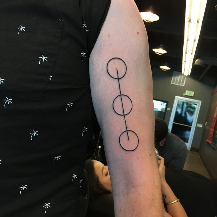 a person with a tattoo on their arm that has a musical note in the middle