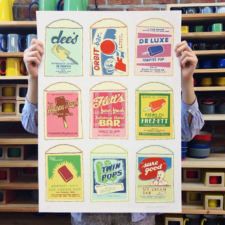 a person holding up a poster with different types of ice cream on it in front of shelves