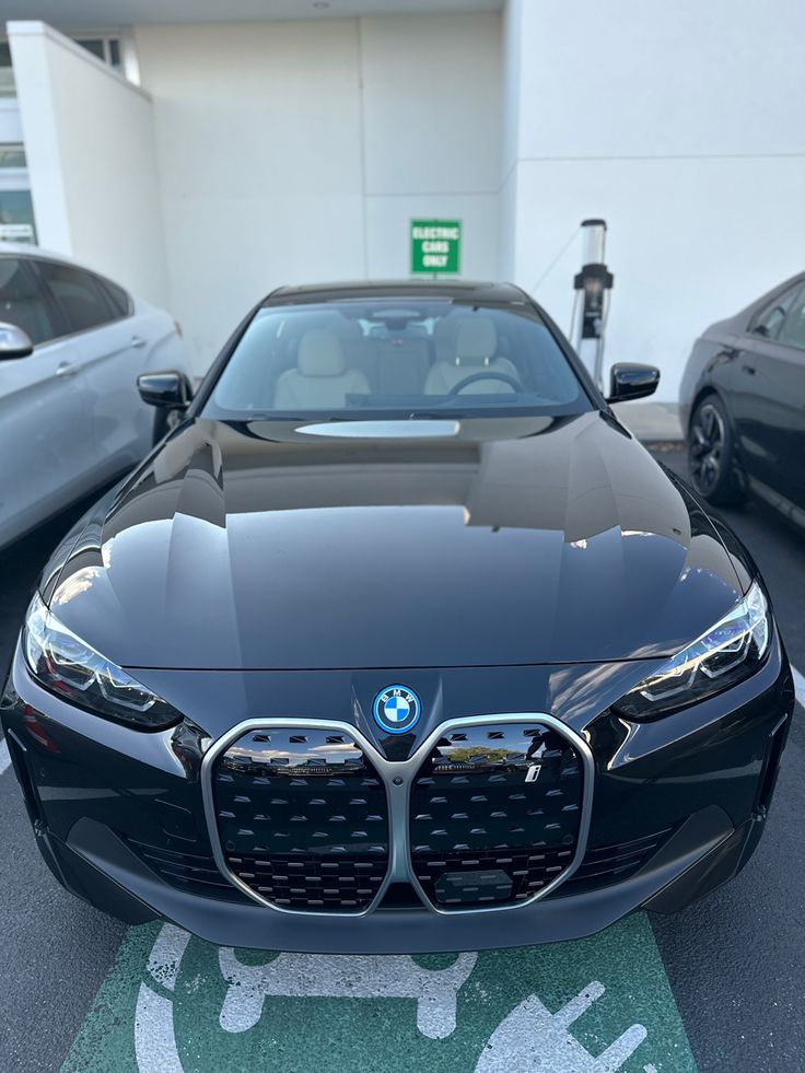 the front end of a black car parked in a parking lot