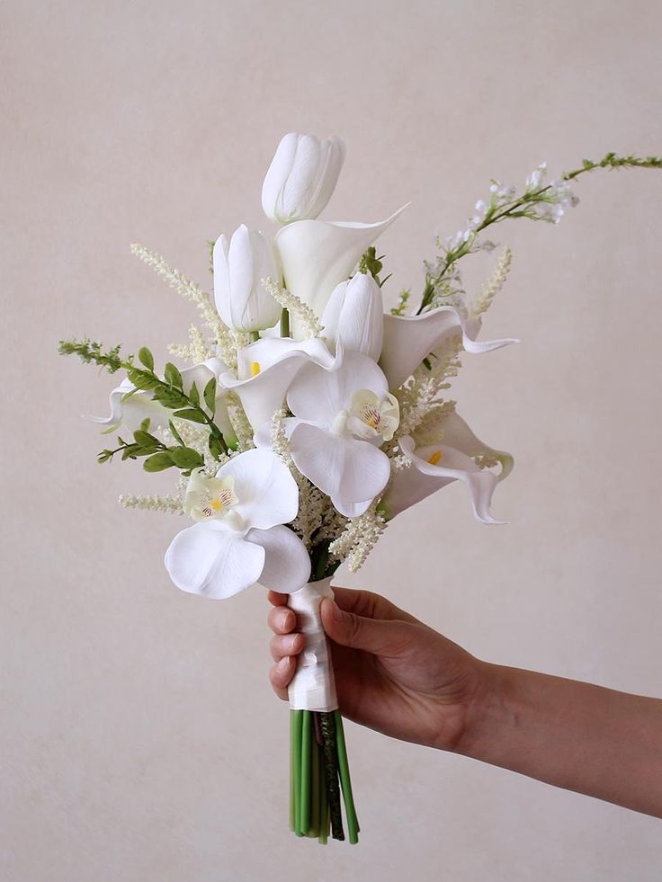 a hand holding a bouquet of white flowers