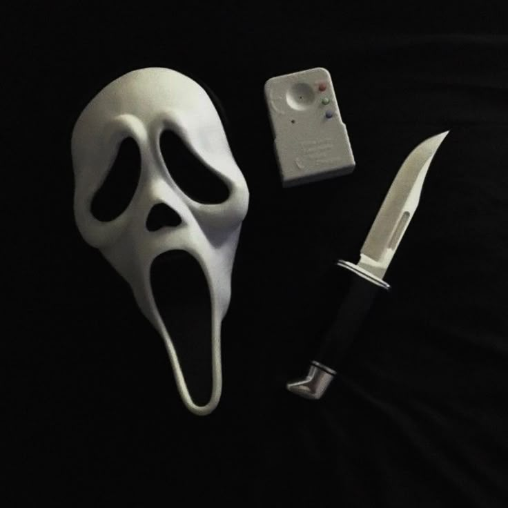 a white mask, knife and lighter on a black background