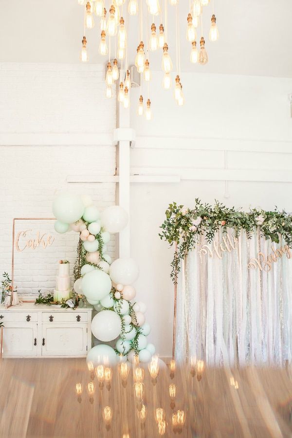 a room filled with lots of white balloons and lights hanging from the ceiling next to a dresser