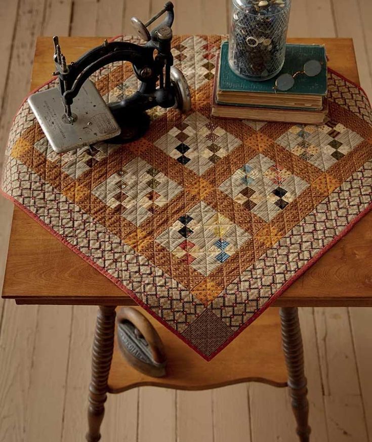 a sewing machine sitting on top of a wooden table next to a stack of books