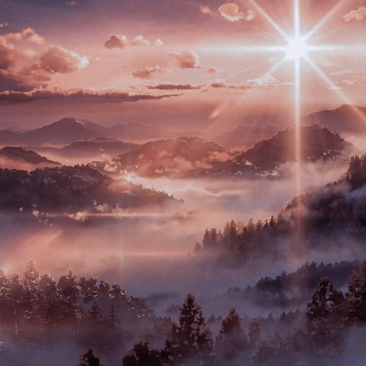 the sun shines brightly over a misty mountain valley with trees and mountains in the foreground