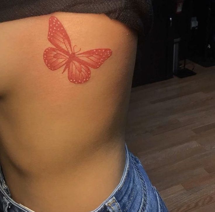 a woman's stomach with a butterfly tattoo on her lower back and the upper half of her body