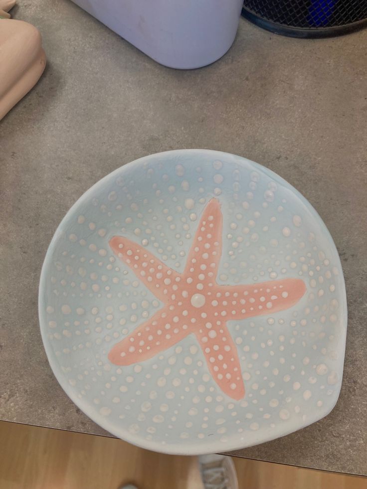 a starfish painted on the bottom of a blue bowl