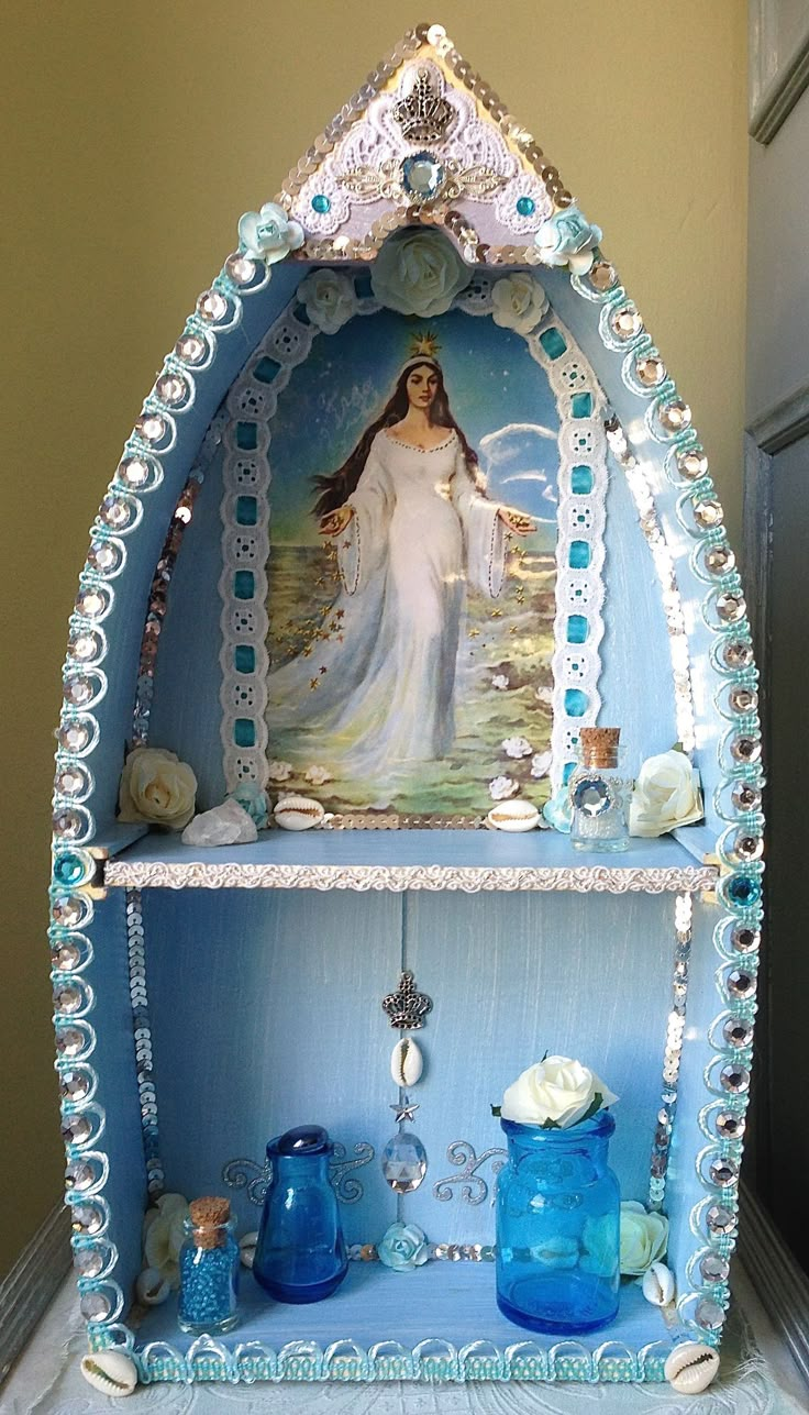 a blue shelf with an image of the virgin mary on it and other items around it