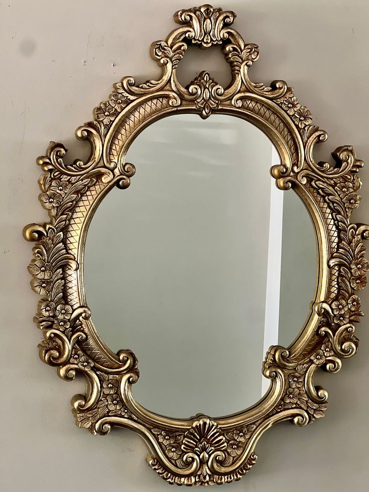 an ornate gold mirror hanging on the wall