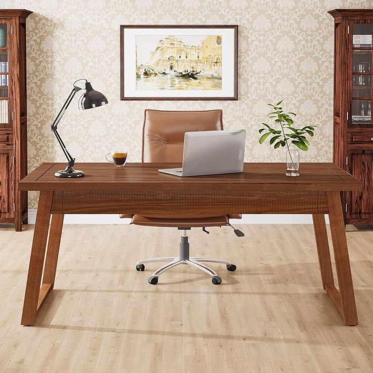 a wooden desk with a laptop on it in front of a bookcase and bookshelf