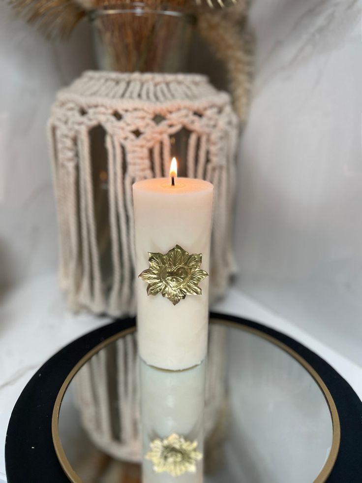 a lit candle sitting on top of a glass plate