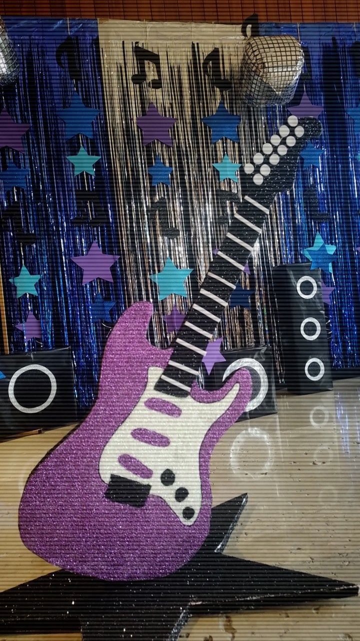 a purple guitar sitting on top of a table next to other musical instruments and decorations