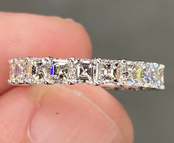 a diamond ring is being held in someone's hand