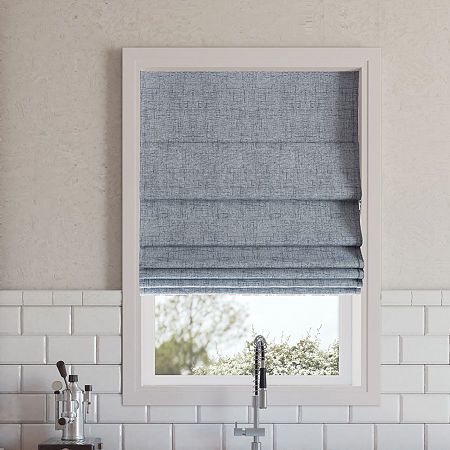 a kitchen sink under a window with roman blinds