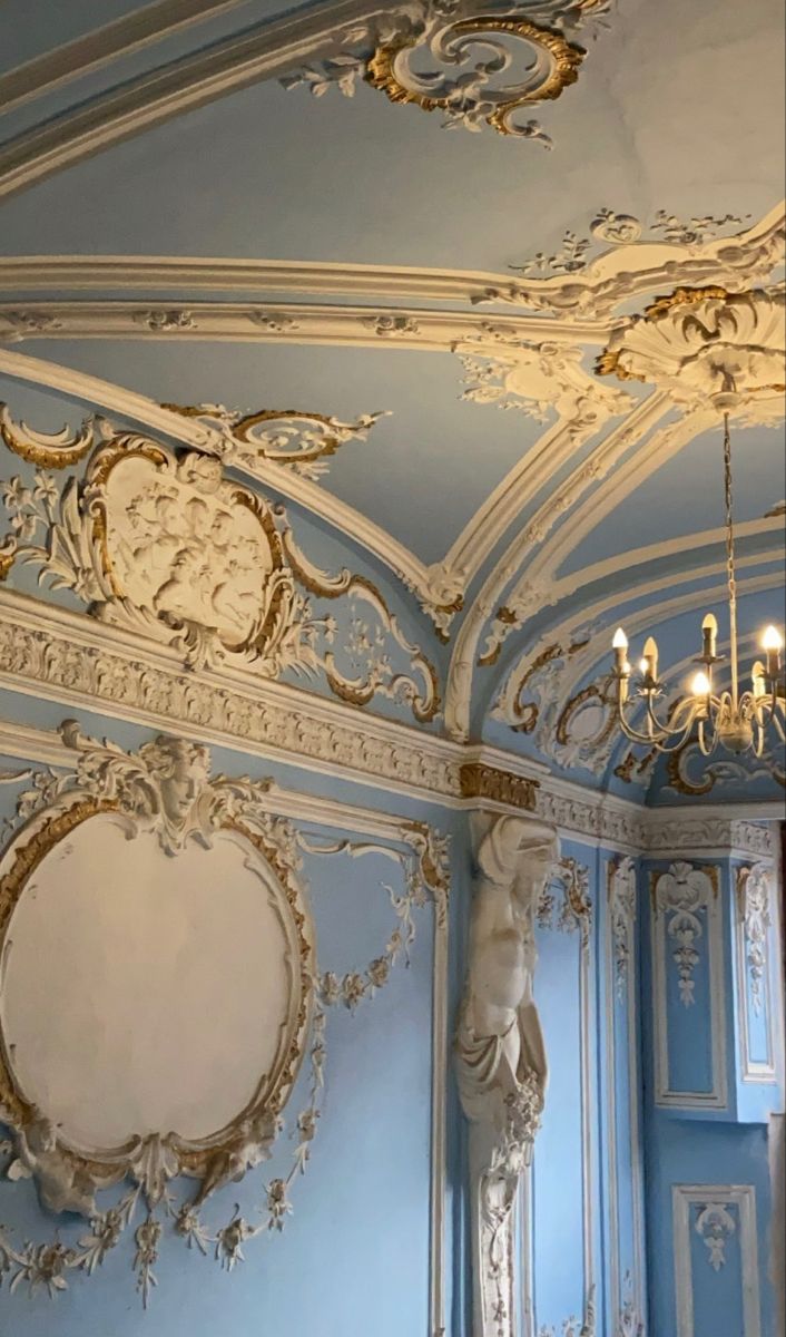 an ornately decorated room with blue walls and gold trimmings on the ceiling