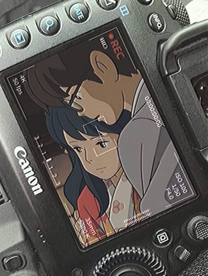 a close up of a cell phone with an anime on the screen