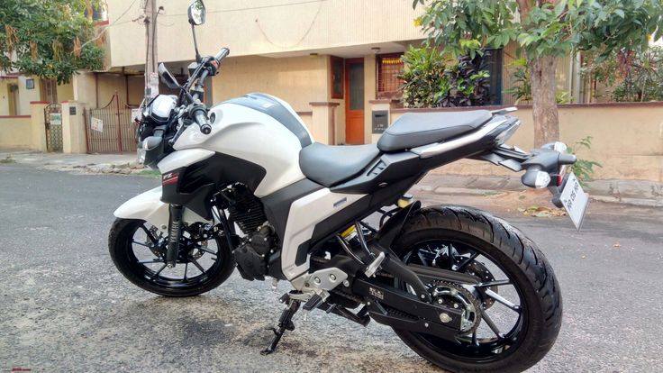 a white and black motorcycle parked in front of a building