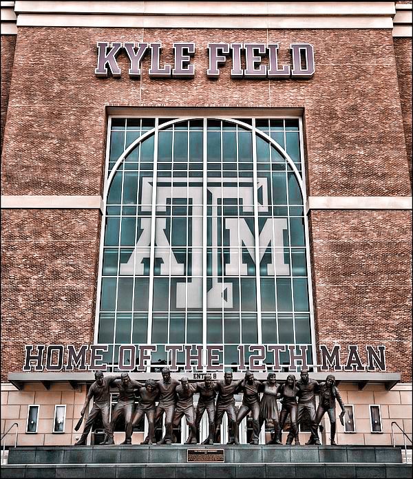 the front of a building that has a sign on it and some statues in front