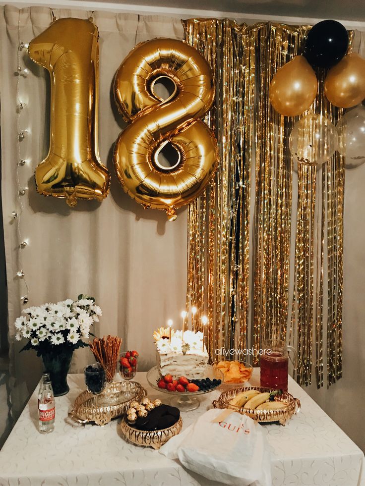 a table topped with lots of food and balloons