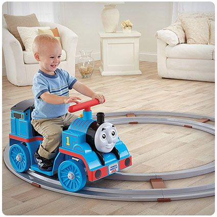 a small child riding on a toy train