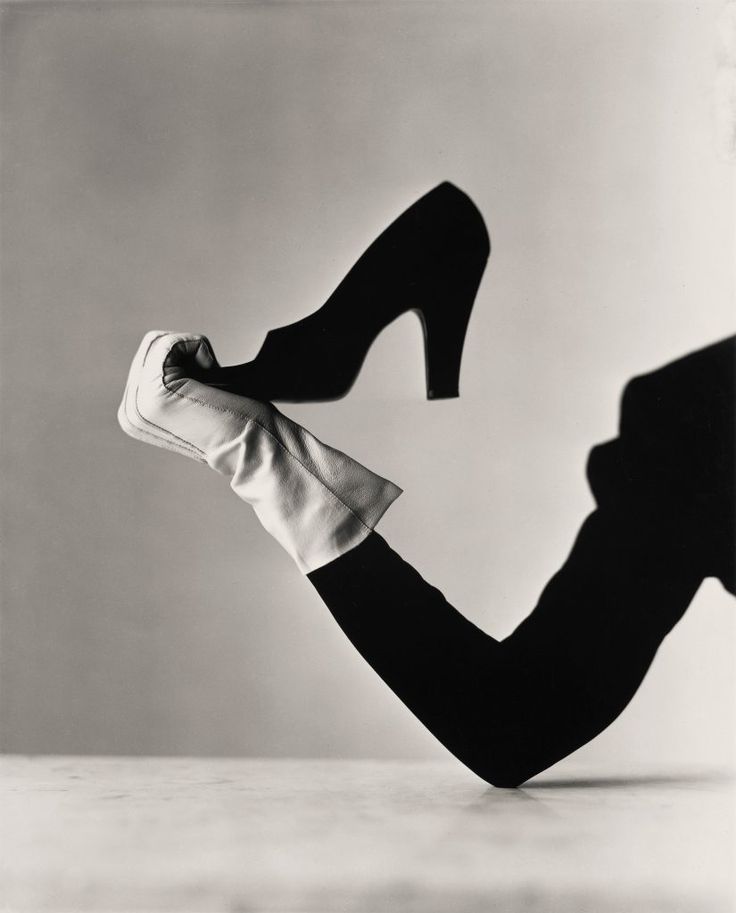 a black and white photo of a woman's legs with high heels in the air