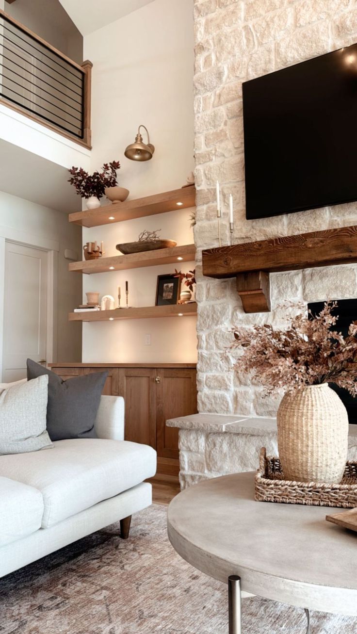 a living room filled with furniture and a flat screen tv mounted on the wall above a fireplace