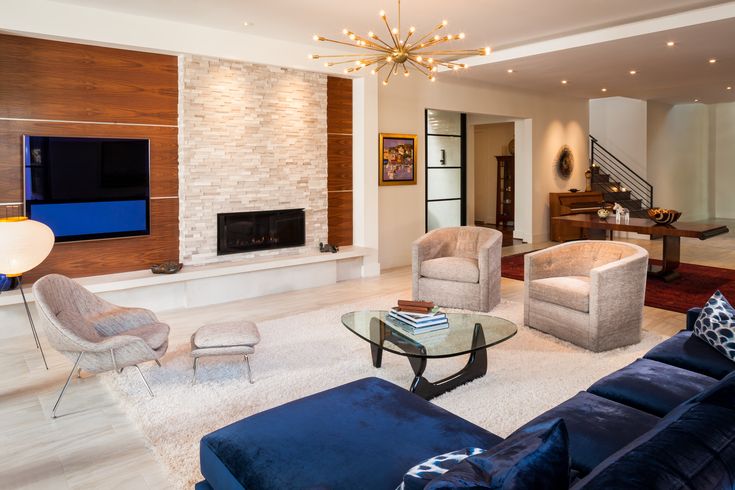 a living room filled with furniture and a flat screen tv mounted on the wall above a fireplace