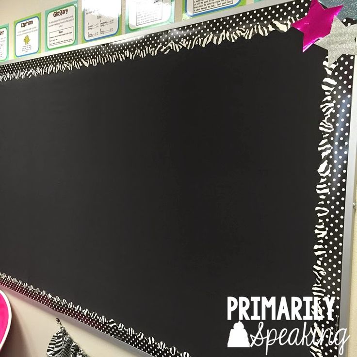 a blackboard with writing on it in front of a bulletin board and other decorations