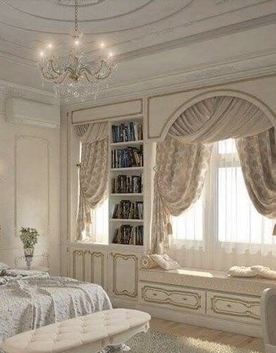 an elegant bedroom with white furniture and chandelier