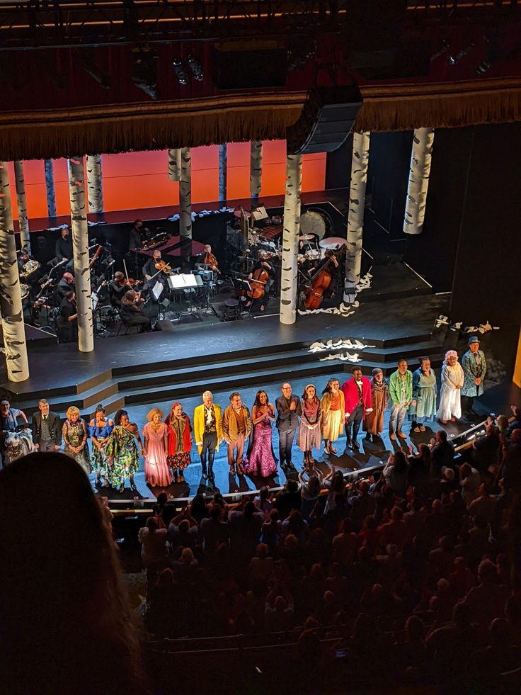 a group of people standing on top of a stage next to each other in front of an audience