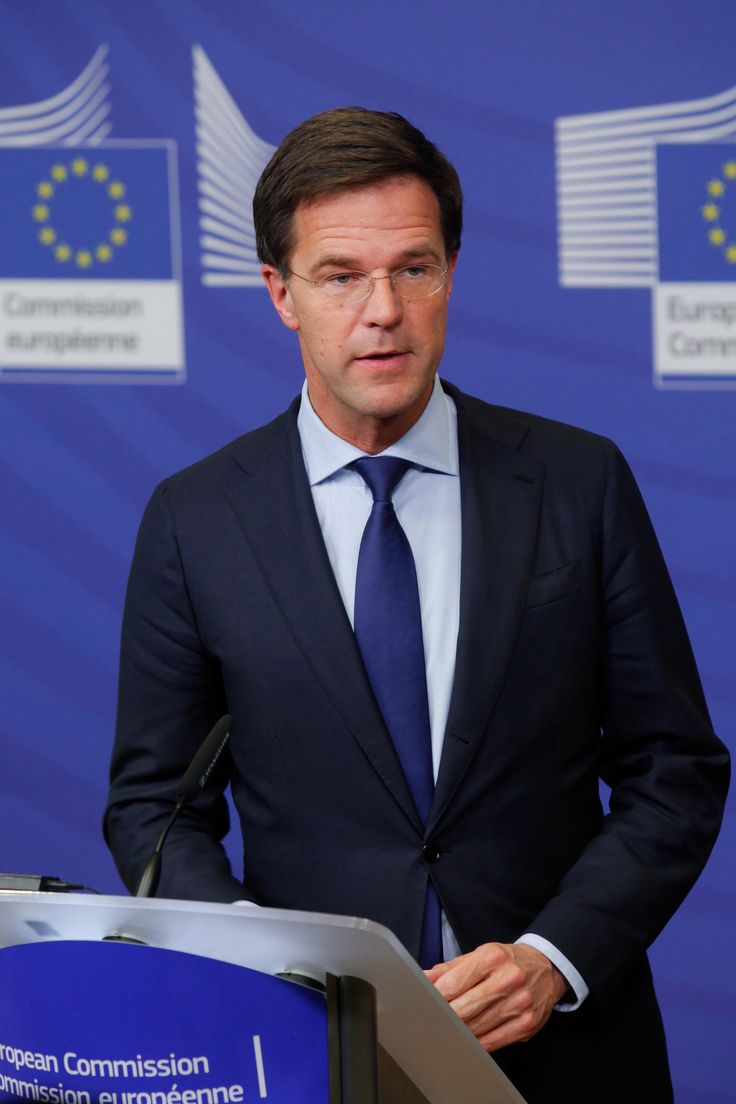 a man in a suit and tie standing at a podium