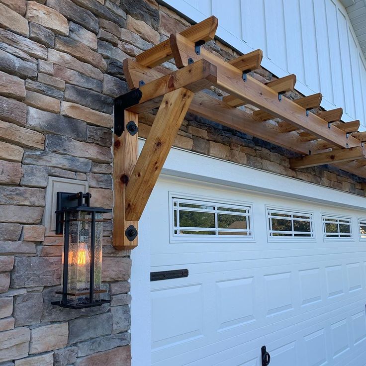 a wooden pergolan attached to the side of a garage