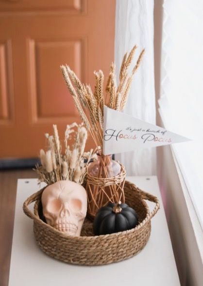 a basket filled with halloween decorations sitting on top of a table next to a door