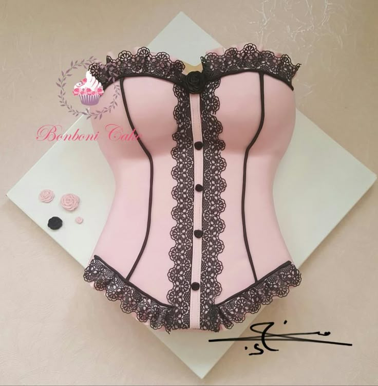 a pink and black corset cake sitting on top of a table