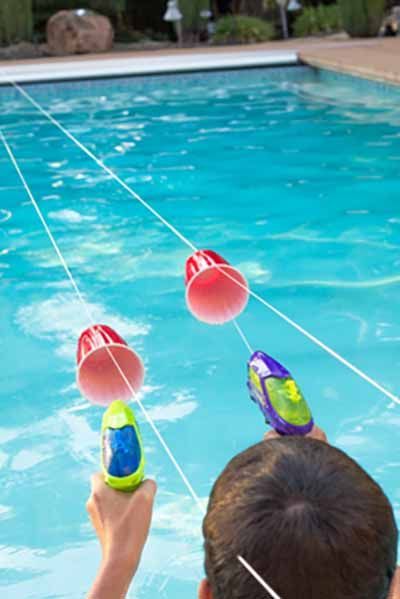 two people are playing in the pool with floaties on their heads and one person is pointing at them