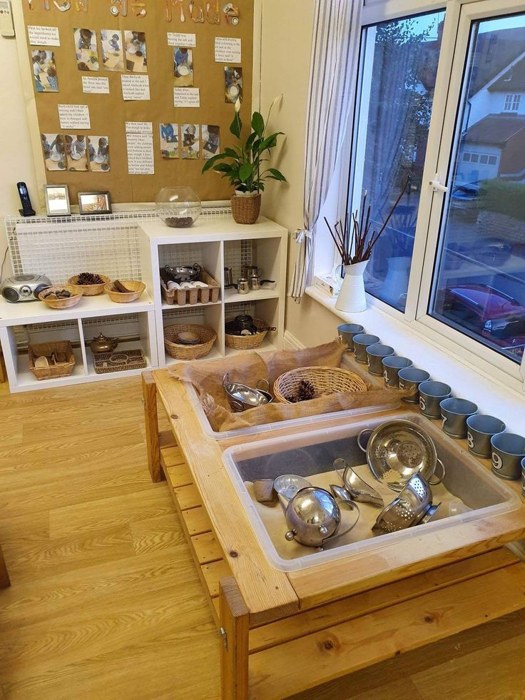 a wooden table with pots and pans on it in front of a large window