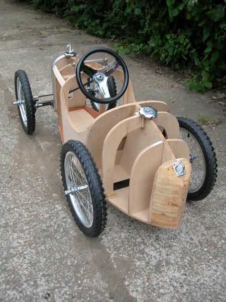 an old fashioned pedal car is sitting on the ground