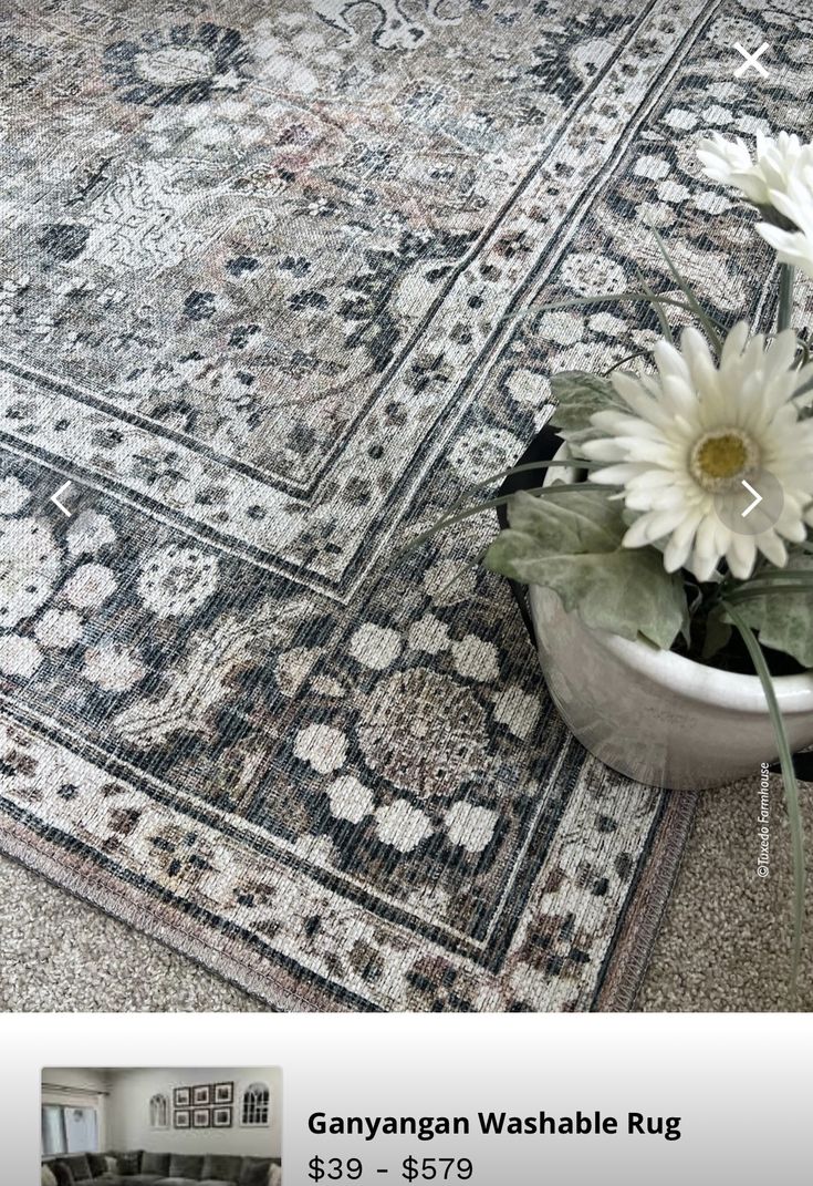 a vase with flowers sitting on top of a rug