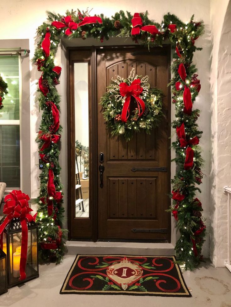 a door decorated with christmas wreaths and red bows