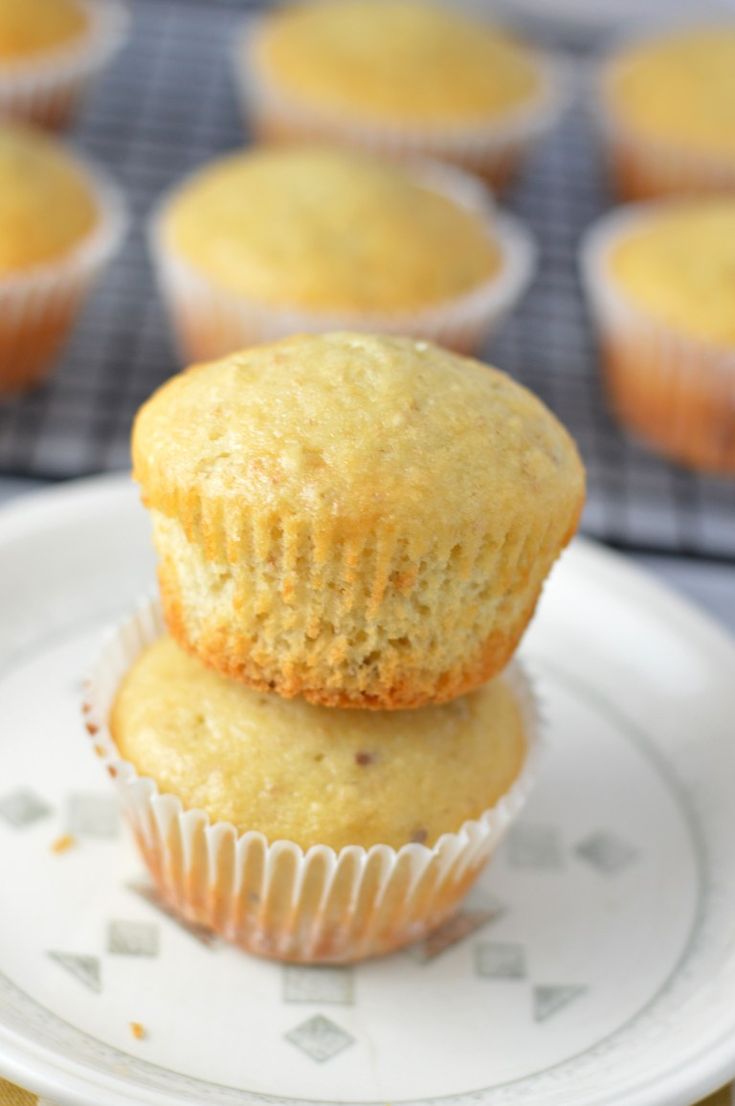 two muffins stacked on top of each other on a plate next to another muffin